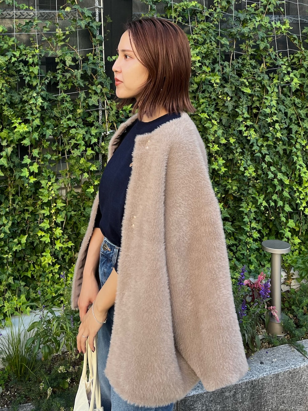 ブルー系のニット/セーター、ブルー系のデニムパンツ、ブラウン系のカーディガン/ボレロを着用したレディースの冬コーディネートの5枚目の写真