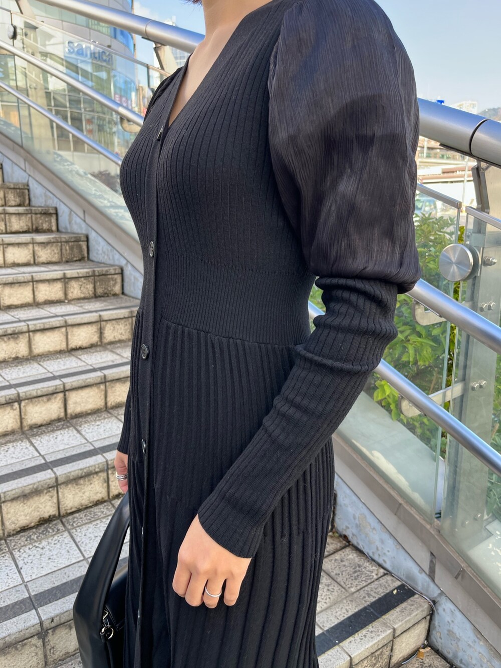 ブラック系のワンピース、ブラック系のハンドバッグ、ベージュ系のブーツを着用したレディースの秋コーディネートの5枚目の写真