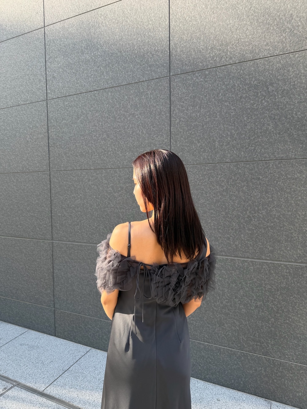 シルバー系のクラッチバッグ、シルバー系のパンプス、グレー系のドレスを着用したレディースの冬コーディネートの8枚目の写真