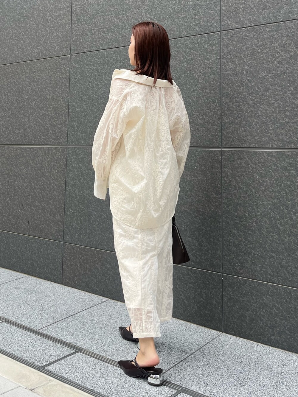 ホワイト系のワンピース、ホワイト系のシャツ/ブラウス、ブラウン系のボストンバッグを着用したレディースの夏コーディネートの3枚目の写真