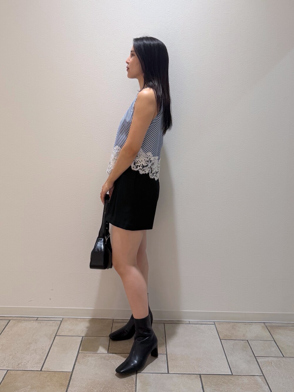 ブラック系のその他パンツ、ブラック系のブーツ、ブルー系のシャツ/ブラウスを着用したレディースの秋コーディネートの2枚目の写真