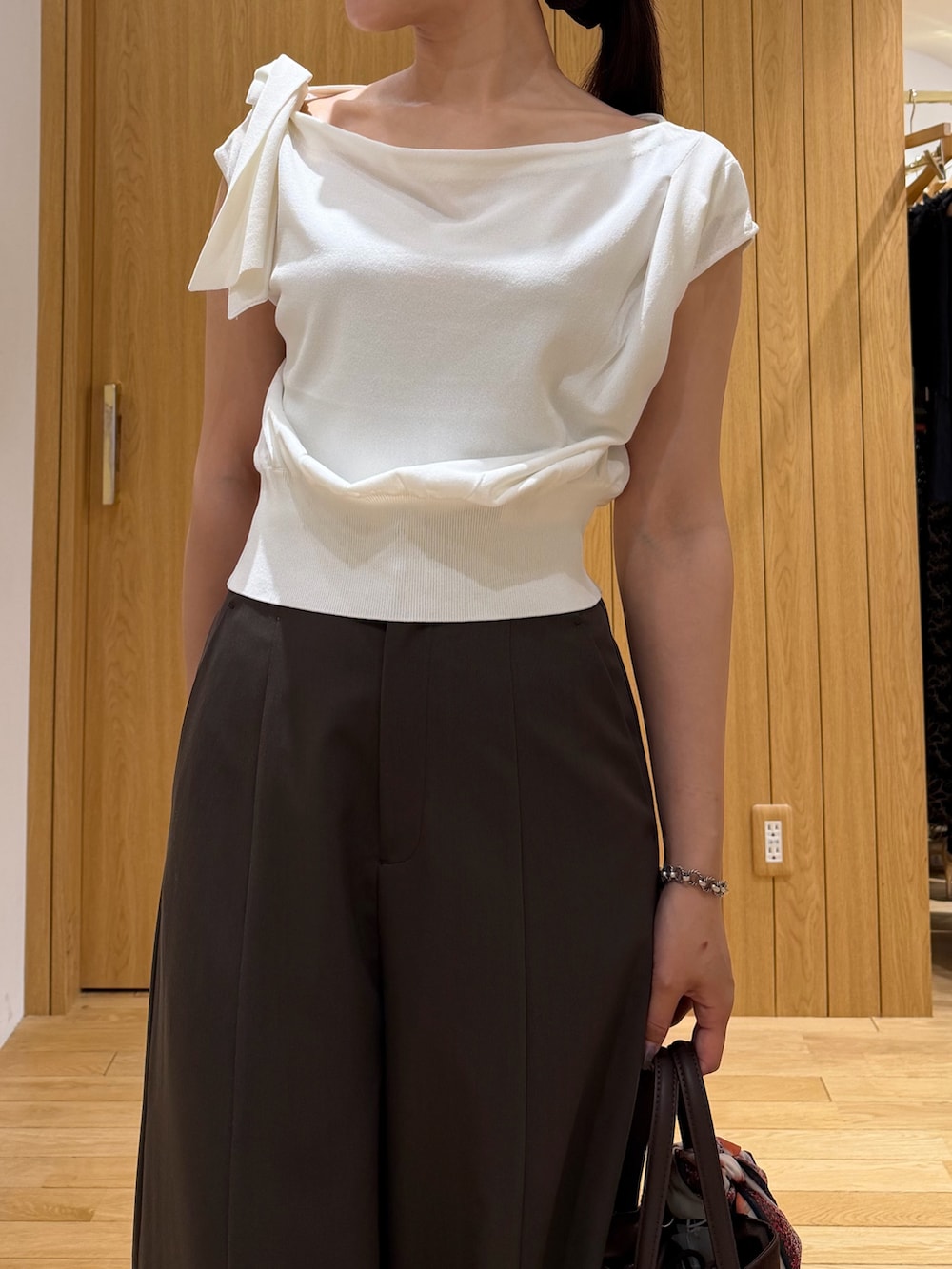 ブラウン系のその他パンツ、ブラウン系のハンドバッグ、ホワイト系のニット/セーターを着用したレディースの夏コーディネートの4枚目の写真
