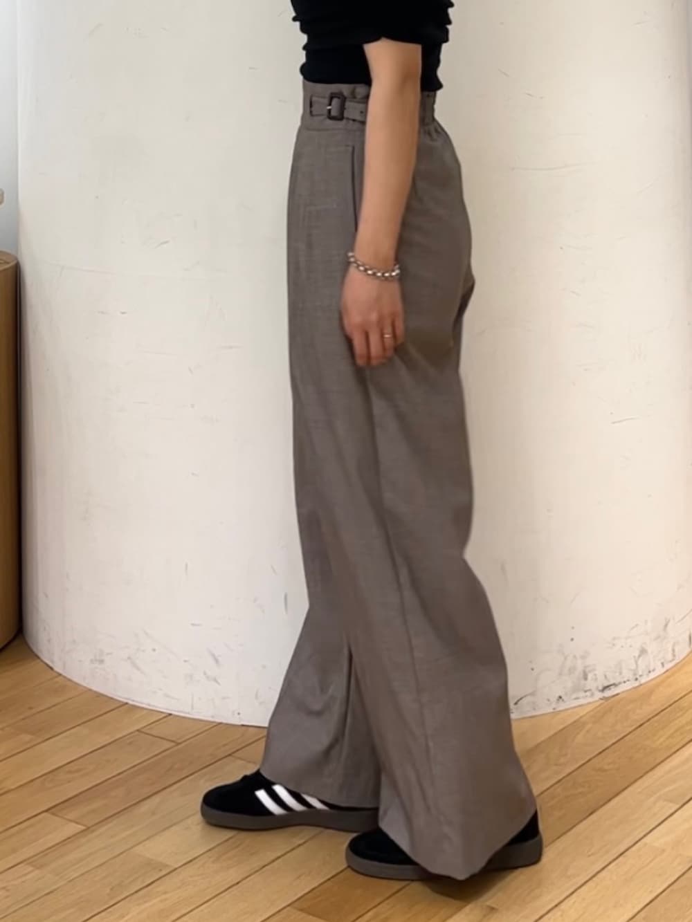 ブラウン系のハンドバッグ、ブラック系のスニーカー、ブラック系のTシャツ/カットソーを着用したレディースの夏コーディネートの4枚目の写真