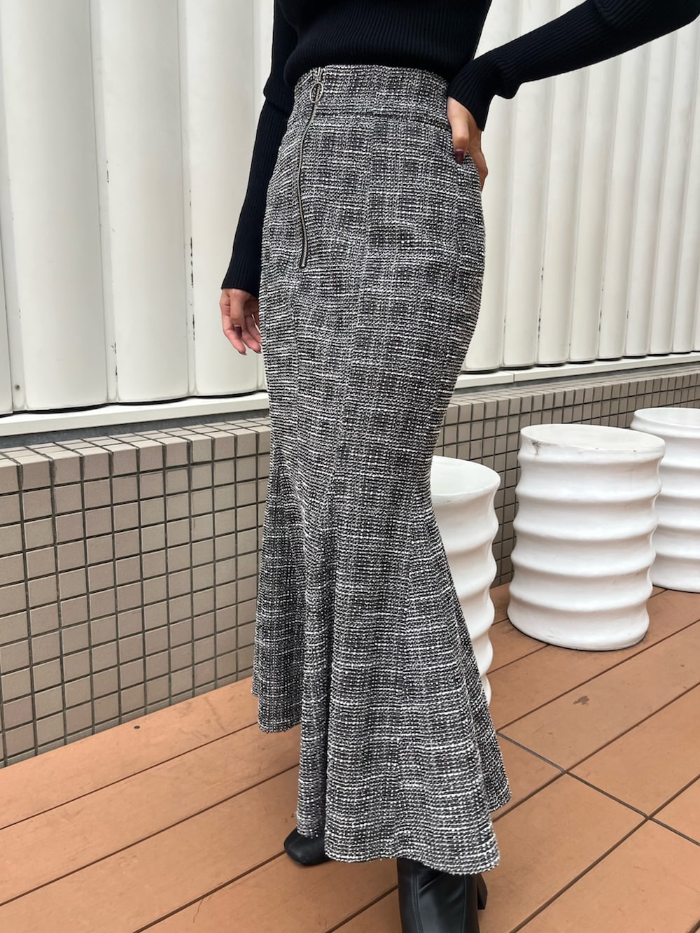 ブラック系のスカート、ブラック系のニット/セーターを着用したレディースの秋コーディネートの4枚目の写真