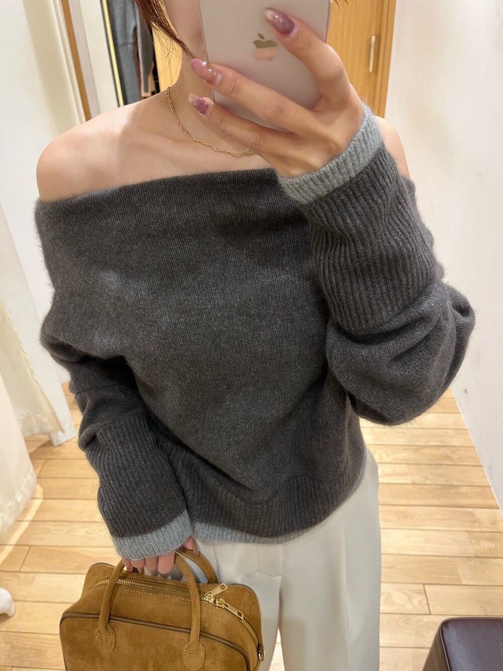 ホワイト系のその他パンツ、ブラック系のブーツ、ブラウン系のハンドバッグを着用したレディースの秋コーディネートの6枚目の写真