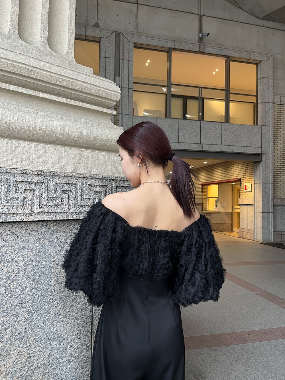 その他のパンプス、ブラック系のパンツドレス、その他のクラッチバッグを着用したレディースの冬コーディネートの9枚目の写真