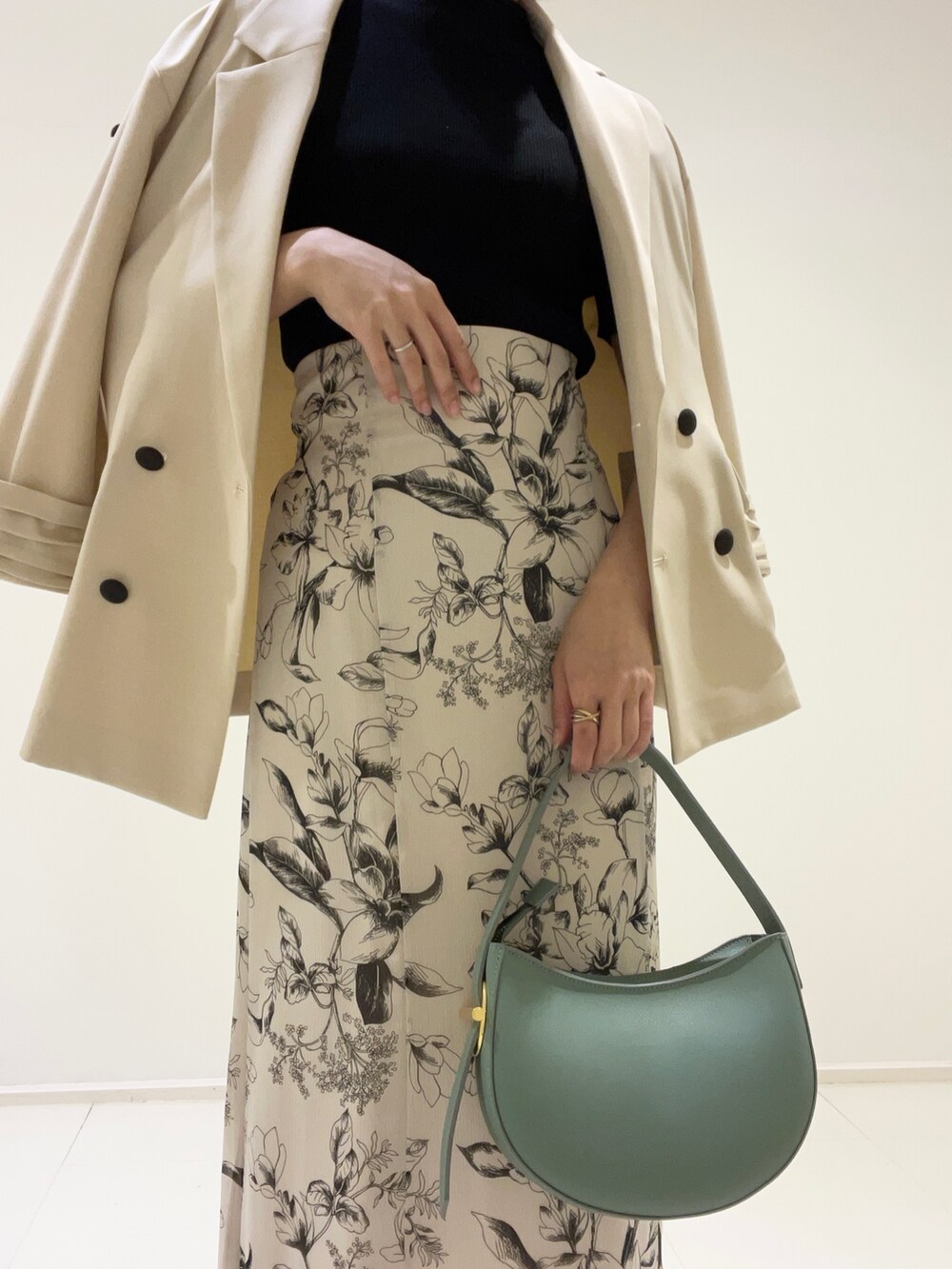 ベージュ系のテーラードジャケット、グリーン系のハンドバッグ、その他のサンダルを着用したレディースの春コーディネートの3枚目の写真