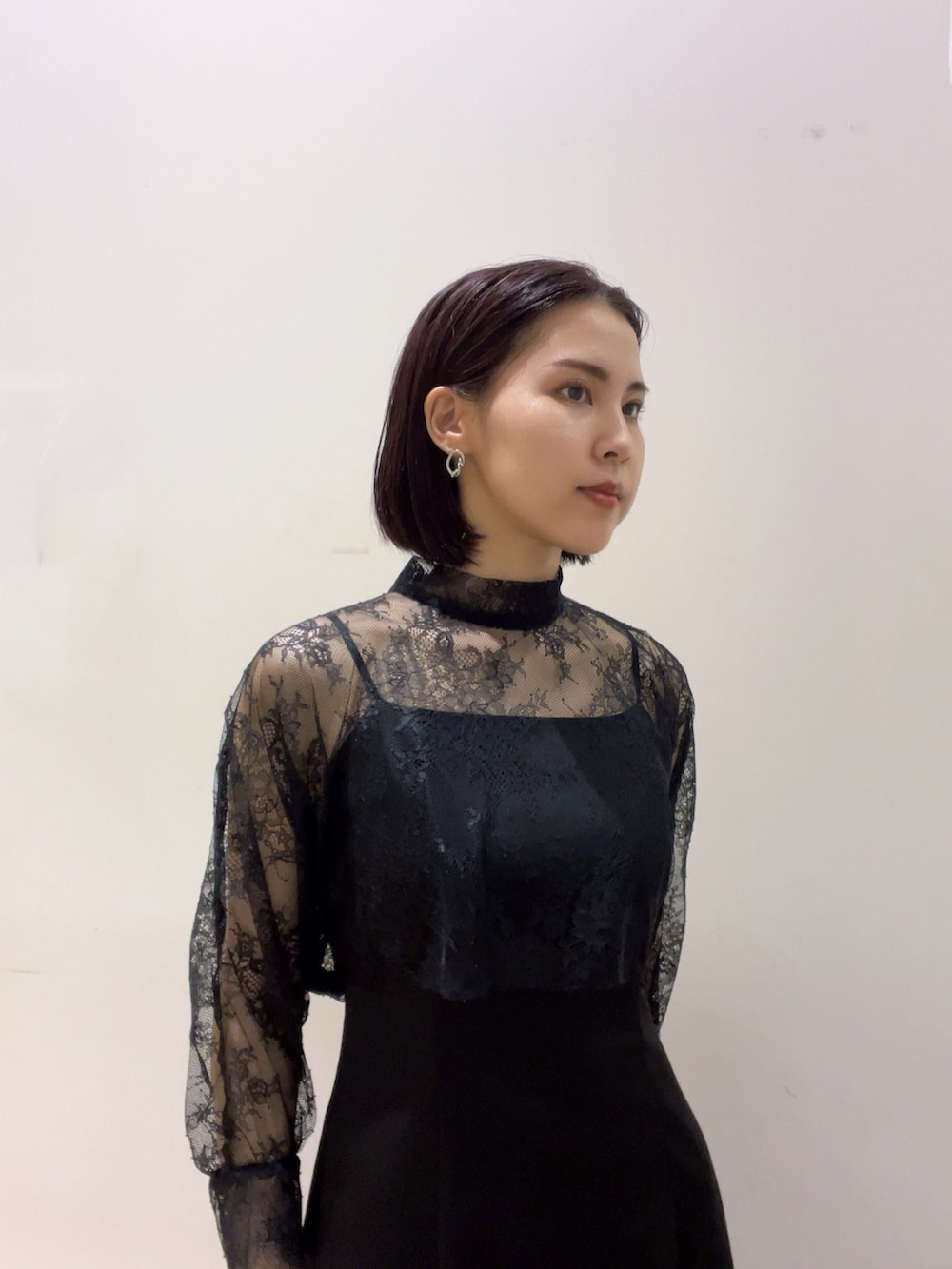 ブラック系のドレス、シルバー系のハンドバッグ、シルバー系のパンプスを着用したレディースの夏コーディネートの2枚目の写真