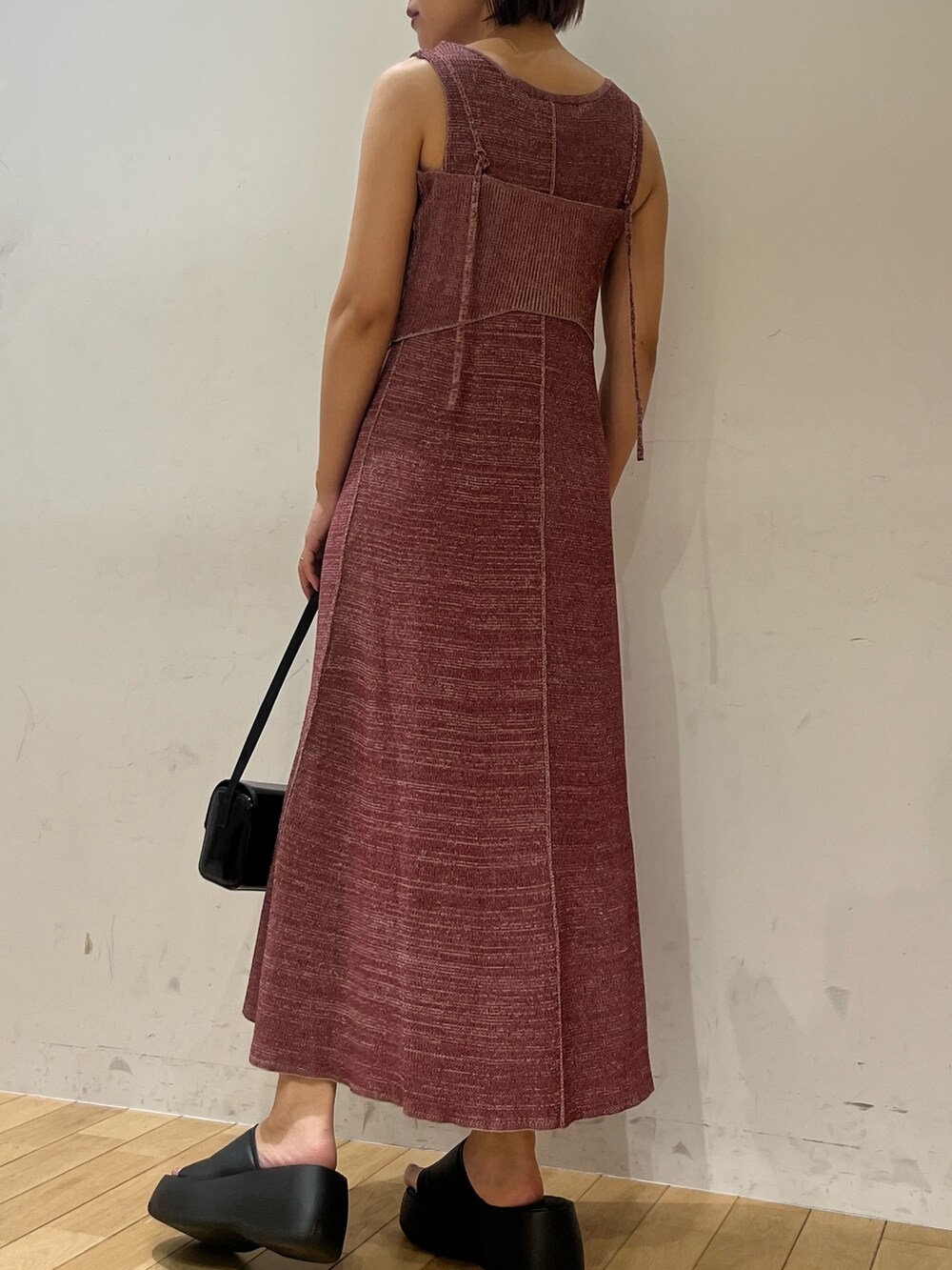 パープル系のワンピース、ブラック系のショルダーバッグ、ブラック系のブーツを着用したレディースの夏コーディネートの6枚目の写真