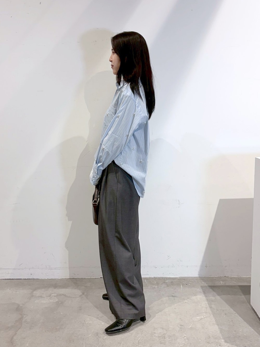 ブルー系のシャツ/ブラウス、グレー系のその他パンツ、ブラック系のブーツを着用したレディースの秋コーディネートの2枚目の写真