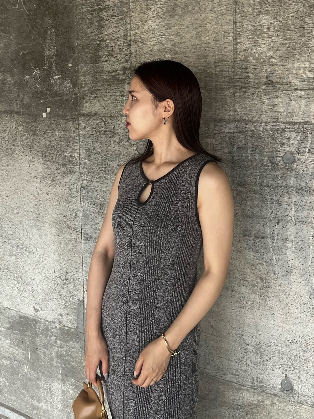 ブラック系のサンダル、グレー系のワンピース、ブラウン系のハンドバッグを着用したレディースの夏コーディネートの4枚目の写真