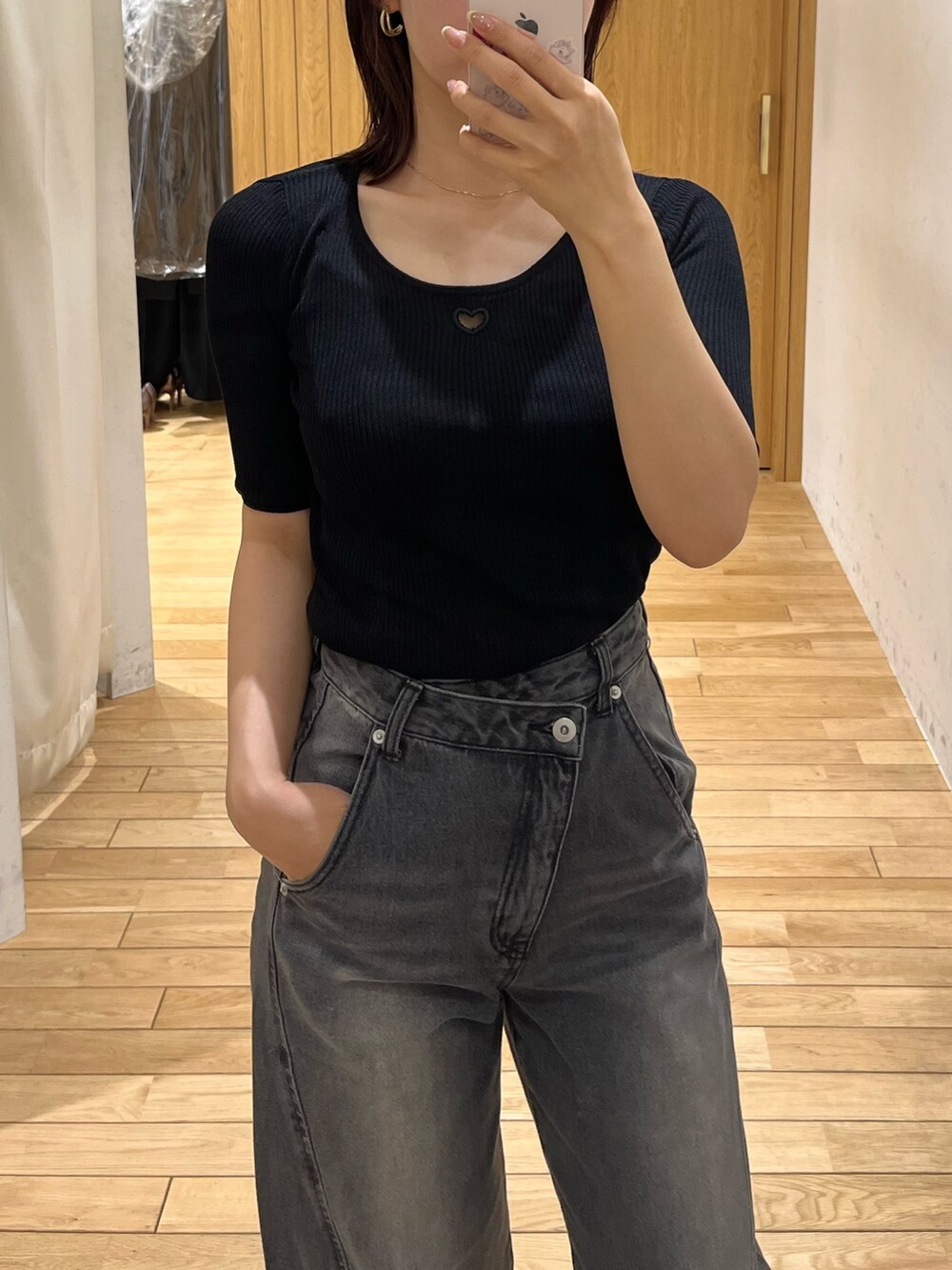 ブラック系のニット/セーター、ブラック系のデニムパンツ、ブラウン系のハンドバッグを着用したレディースの春コーディネートの5枚目の写真