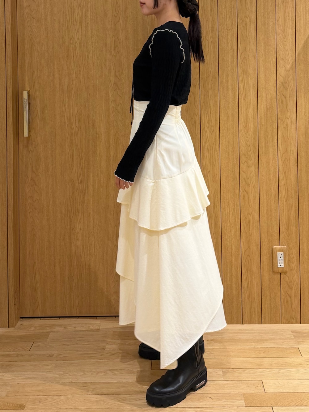 ブラック系のテーラードジャケット、ホワイト系のスカート、ブラック系のニット/セーターを着用したレディースの春コーディネートの4枚目の写真