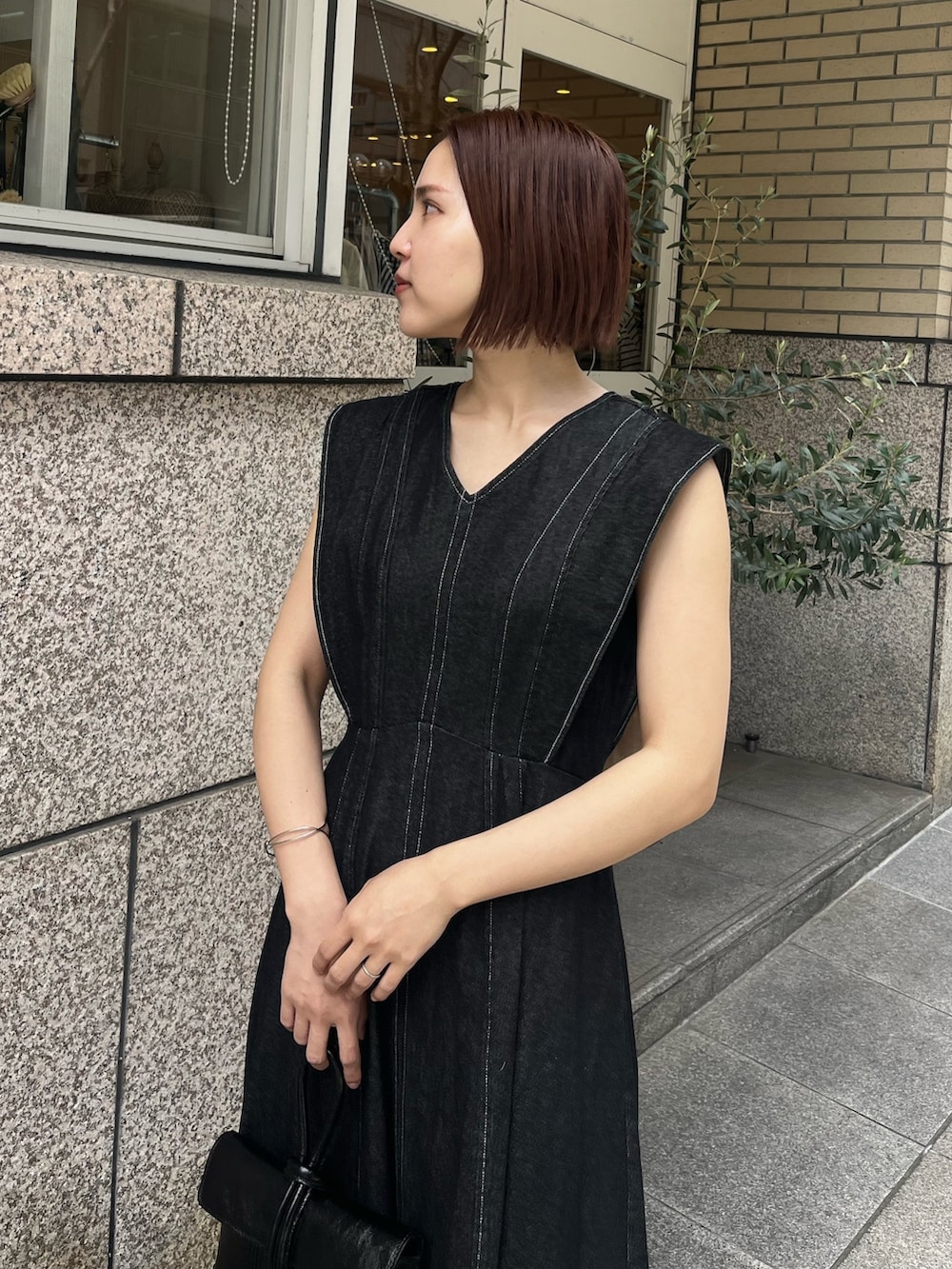 ブラック系のワンピース、その他のサンダル、ブラック系のハンドバッグを着用したレディースの春コーディネートの5枚目の写真