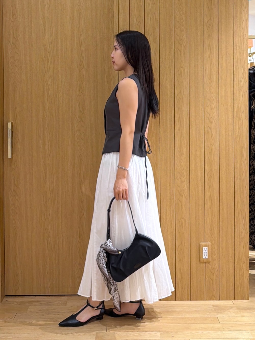 ブラック系のパンプス、グレー系のワンピース、ブラック系のハンドバッグを着用したレディースの夏コーディネートの2枚目の写真