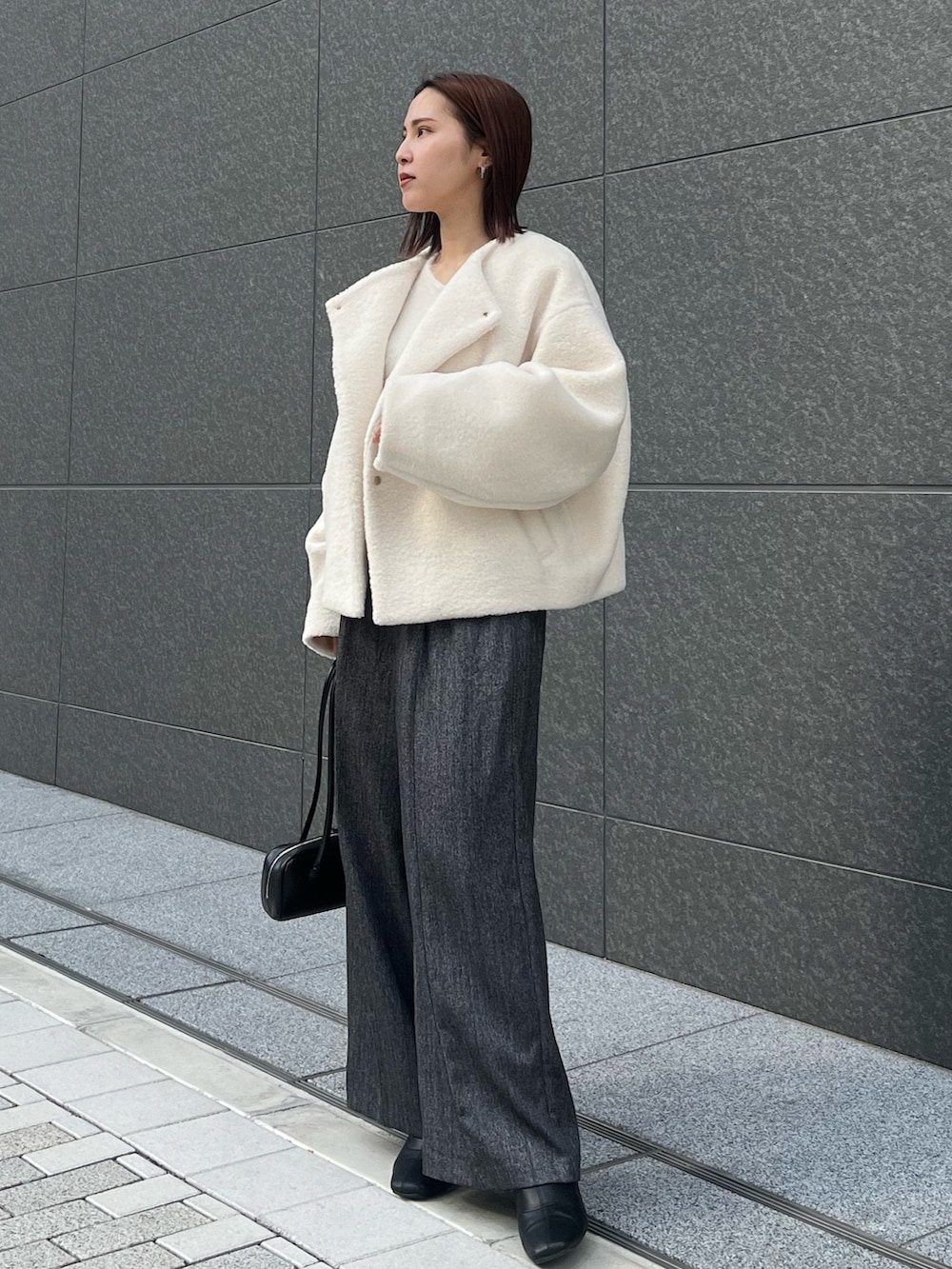 グレー系のその他パンツ、ホワイト系のニット/セーター、ホワイト系のブルゾンを着用したレディースの冬コーディネートの2枚目の写真