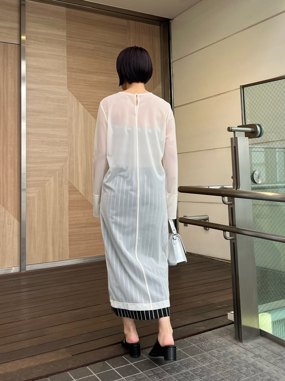 ホワイト系のTシャツ/カットソー、ブラック系のサンダル、ブラック系のスカートを着用したレディースの春コーディネートの3枚目の写真