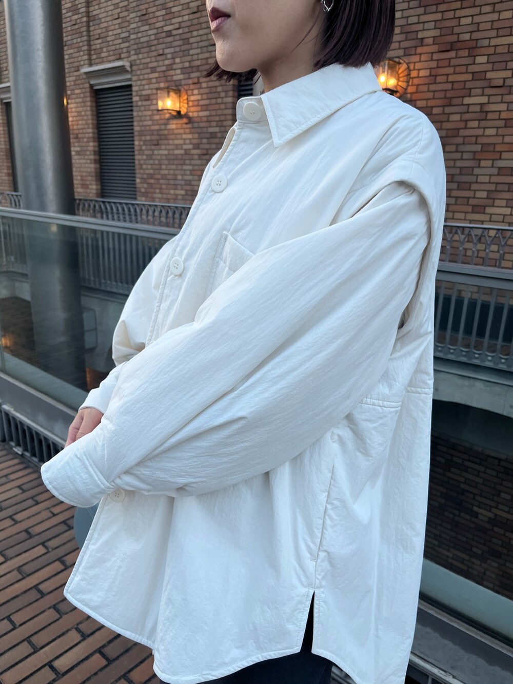 ブルー系のショルダーバッグ、グレー系のスカート、ホワイト系のブルゾンを着用したレディースの冬コーディネートの4枚目の写真