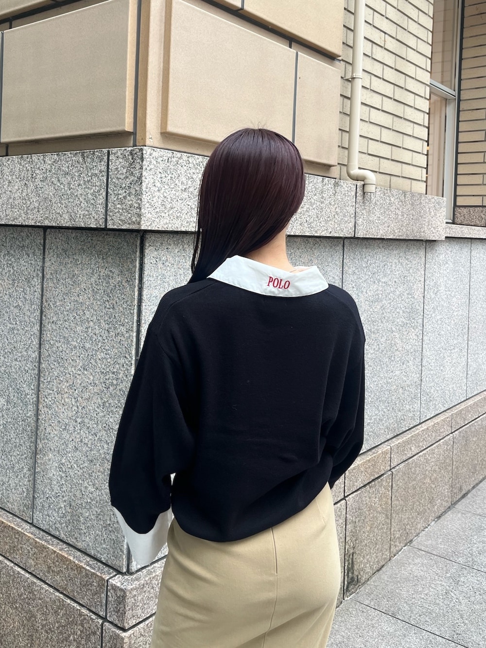 ベージュ系のスカート、ホワイト系のハンドバッグ、ブラック系のブーツを着用したレディースの秋コーディネートの5枚目の写真