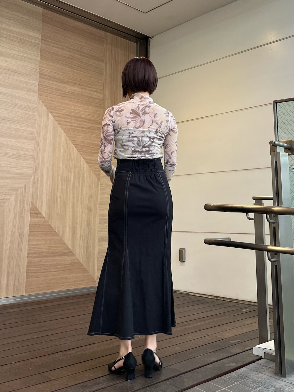 ブラック系のスカート、ブラック系のパンプス、イエロー系のTシャツ/カットソーを着用したレディースの春コーディネートの3枚目の写真