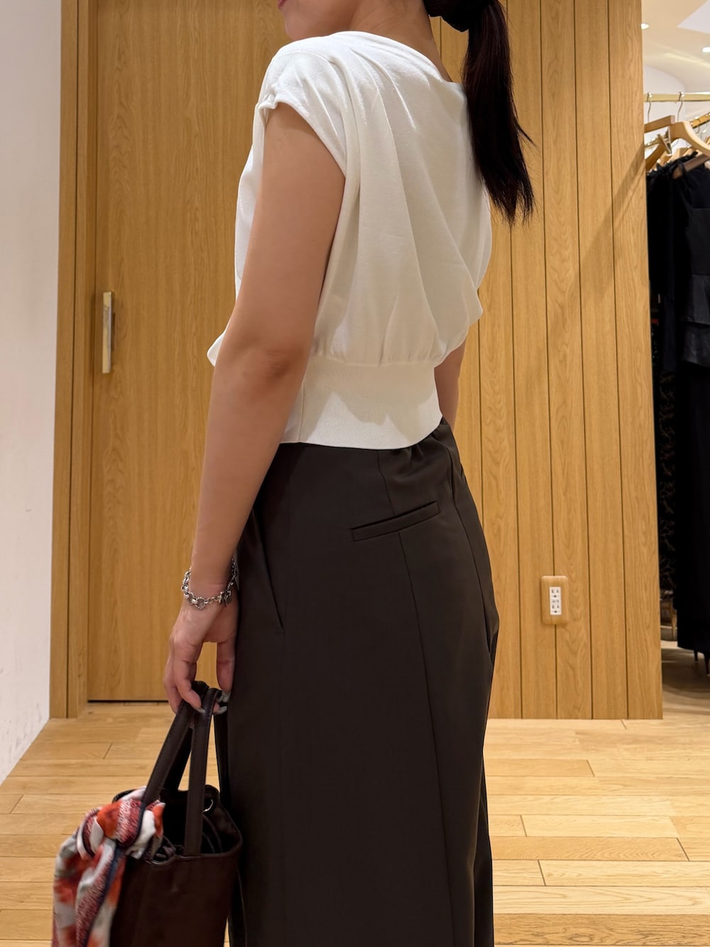 ブラウン系のその他パンツ、ブラウン系のハンドバッグ、ホワイト系のニット/セーターを着用したレディースの夏コーディネートの5枚目の写真