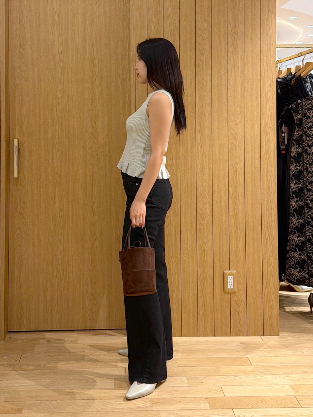 ブラック系のデニムパンツ、ブラウン系のハンドバッグ、グリーン系のパンプスを着用したレディースの夏コーディネートの2枚目の写真