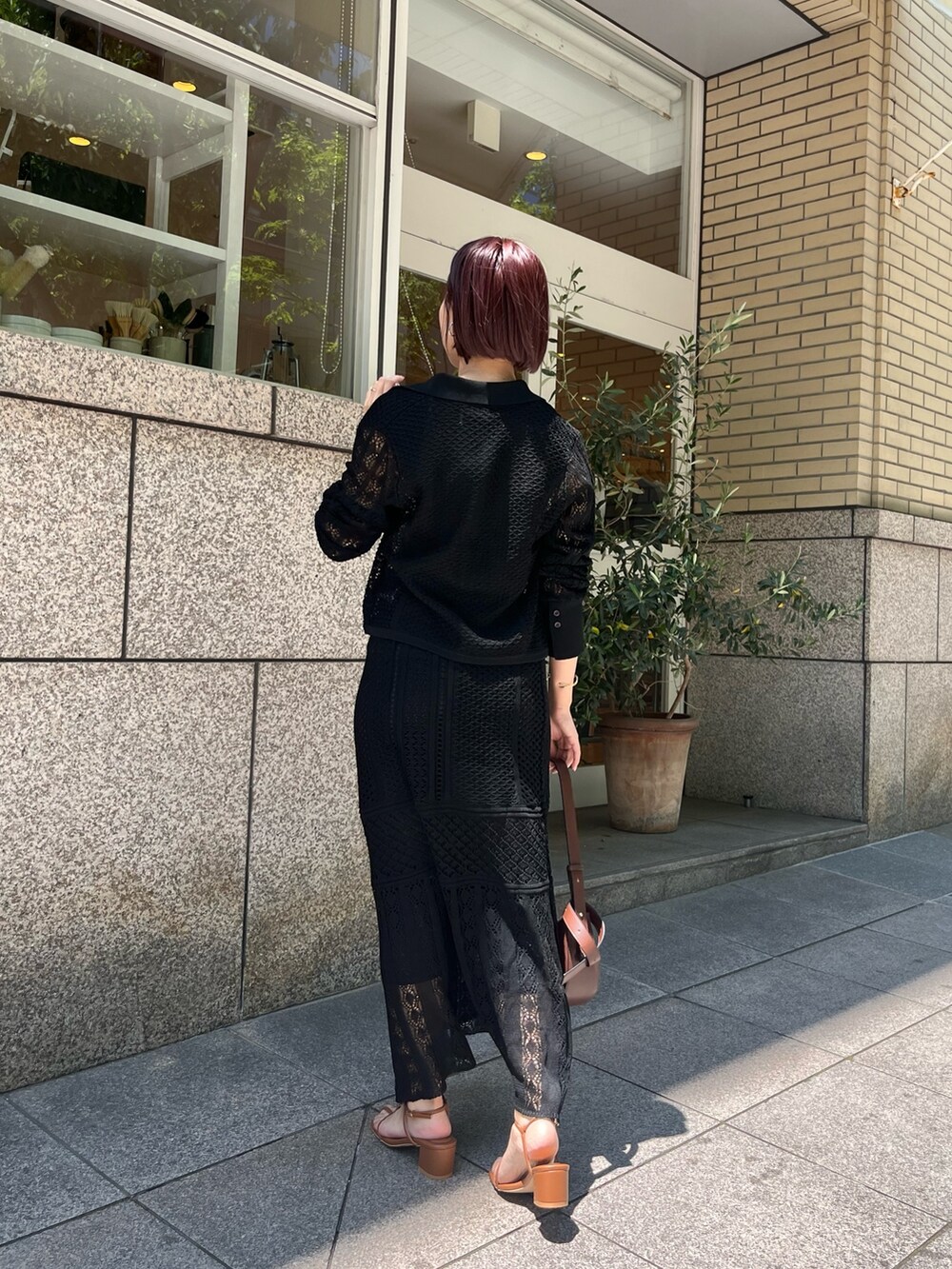 ブラック系のスカート、ブラウン系のショルダーバッグ、イエロー系のサンダルを着用したレディースの春コーディネートの3枚目の写真