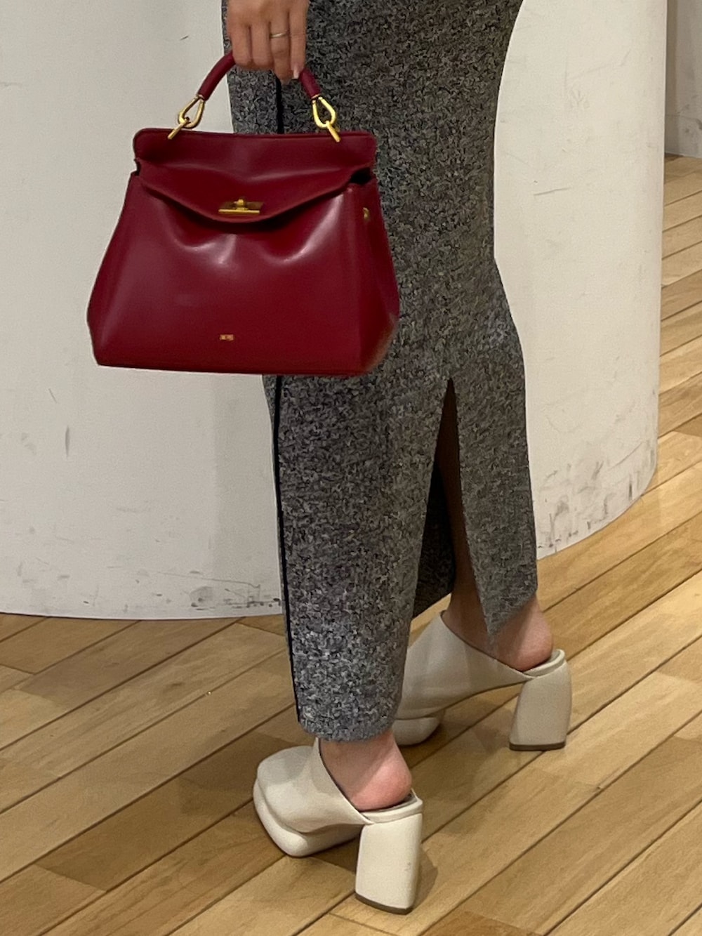 ブラック系のワンピース、レッド系のハンドバッグ、ホワイト系のサンダルを着用したレディースの春コーディネートの6枚目の写真