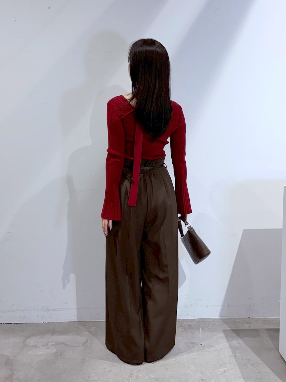 ブラウン系のその他パンツ、ブラック系のブーツ、レッド系のニット/セーターを着用したレディースの夏コーディネートの3枚目の写真