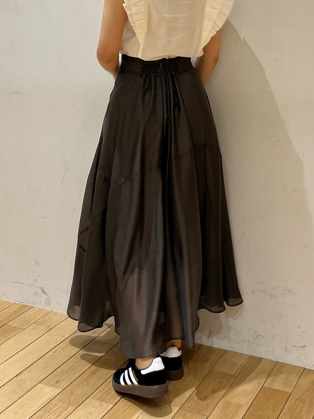 ブラック系のスニーカー、ホワイト系のシャツ/ブラウス、グレー系のスカートを着用したレディースの春コーディネートの7枚目の写真