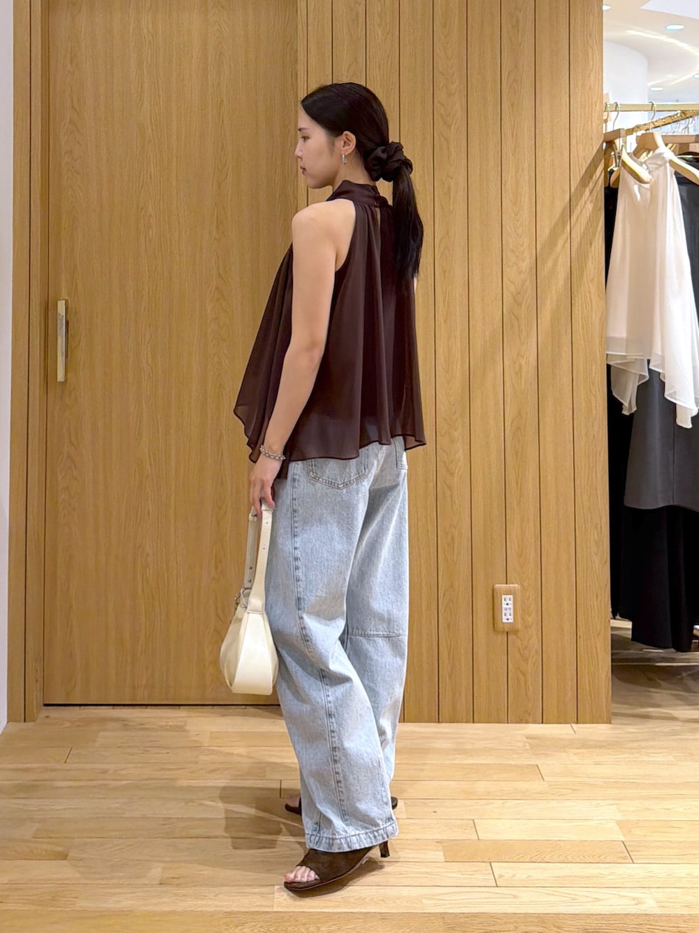 ブルー系のデニムパンツ、ブラウン系のシャツ/ブラウス、ブラウン系のサンダルを着用したレディースの夏コーディネートの2枚目の写真