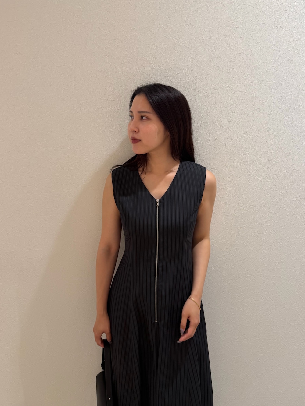 ブラック系のワンピース、ブラック系のハンドバッグ、シルバー系のパンプスを着用したレディースの夏コーディネートの4枚目の写真