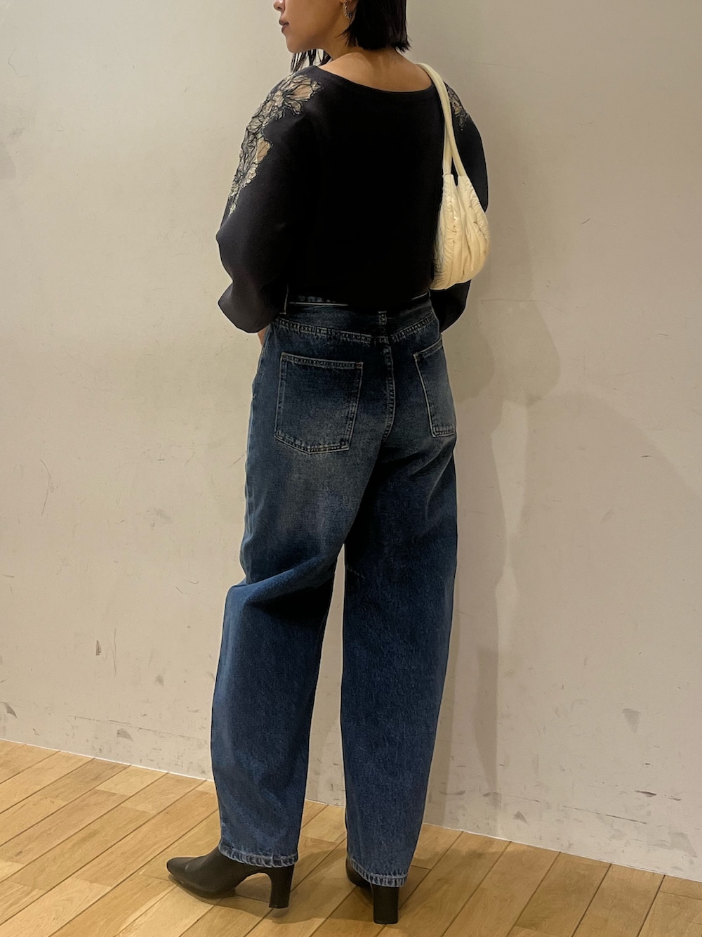 ブラック系のブーツ、ブルー系のデニムパンツ、グレー系のニット/セーターを着用したレディースの秋コーディネートの2枚目の写真