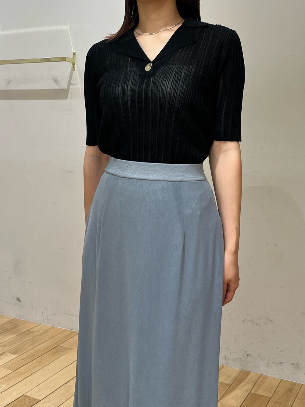 ブルー系のスカート、ブラック系のTシャツ/カットソー、ブラック系のスニーカーを着用したレディースの春コーディネートの4枚目の写真