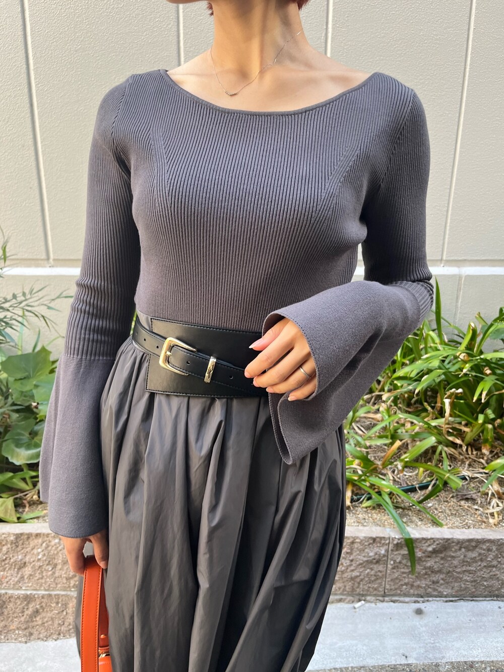 グレー系のワンピース、オレンジ系のショルダーバッグ、グレー系のその他アウターを着用したレディースの秋コーディネートの6枚目の写真