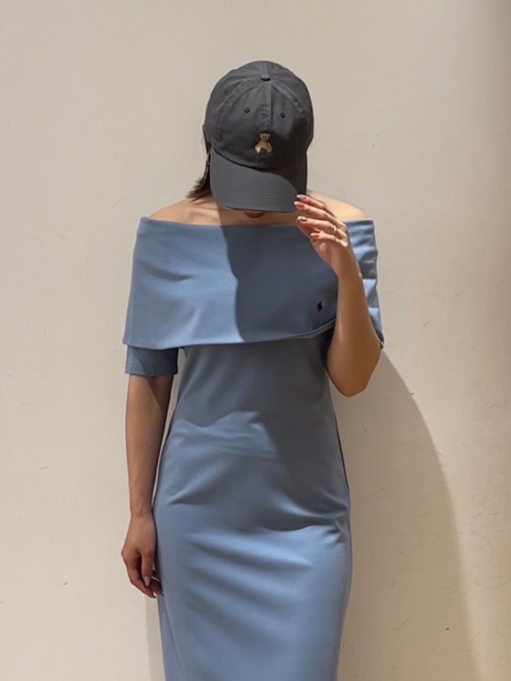 ブルー系のワンピース、ホワイト系のサンダル、グレー系のキャップを着用したレディースの春コーディネートの7枚目の写真