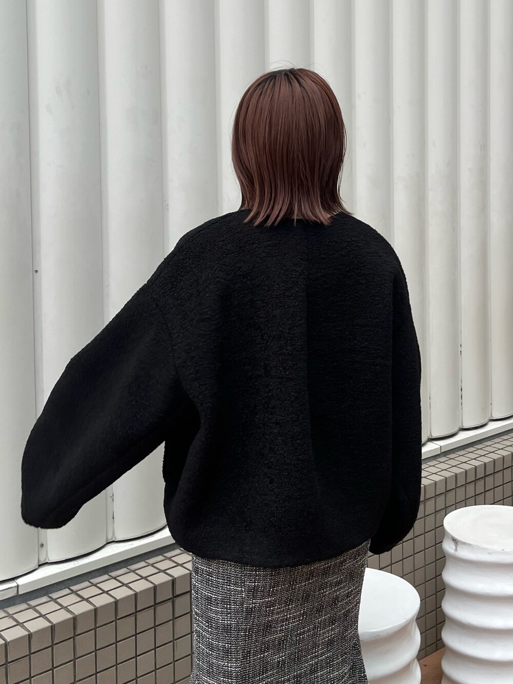 ブラック系のブルゾン、ブラック系のニット/セーター、ブラック系のスカートを着用したレディースの秋コーディネートの6枚目の写真