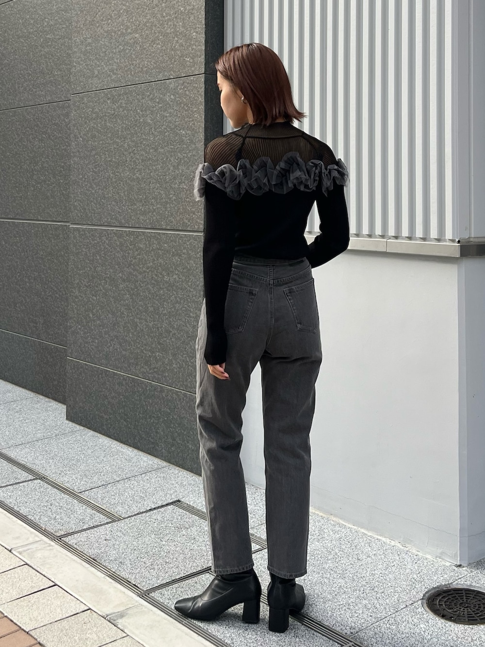 ブラック系のデニムパンツ、ブラック系のニット/セーターを着用したレディースの秋コーディネートの2枚目の写真