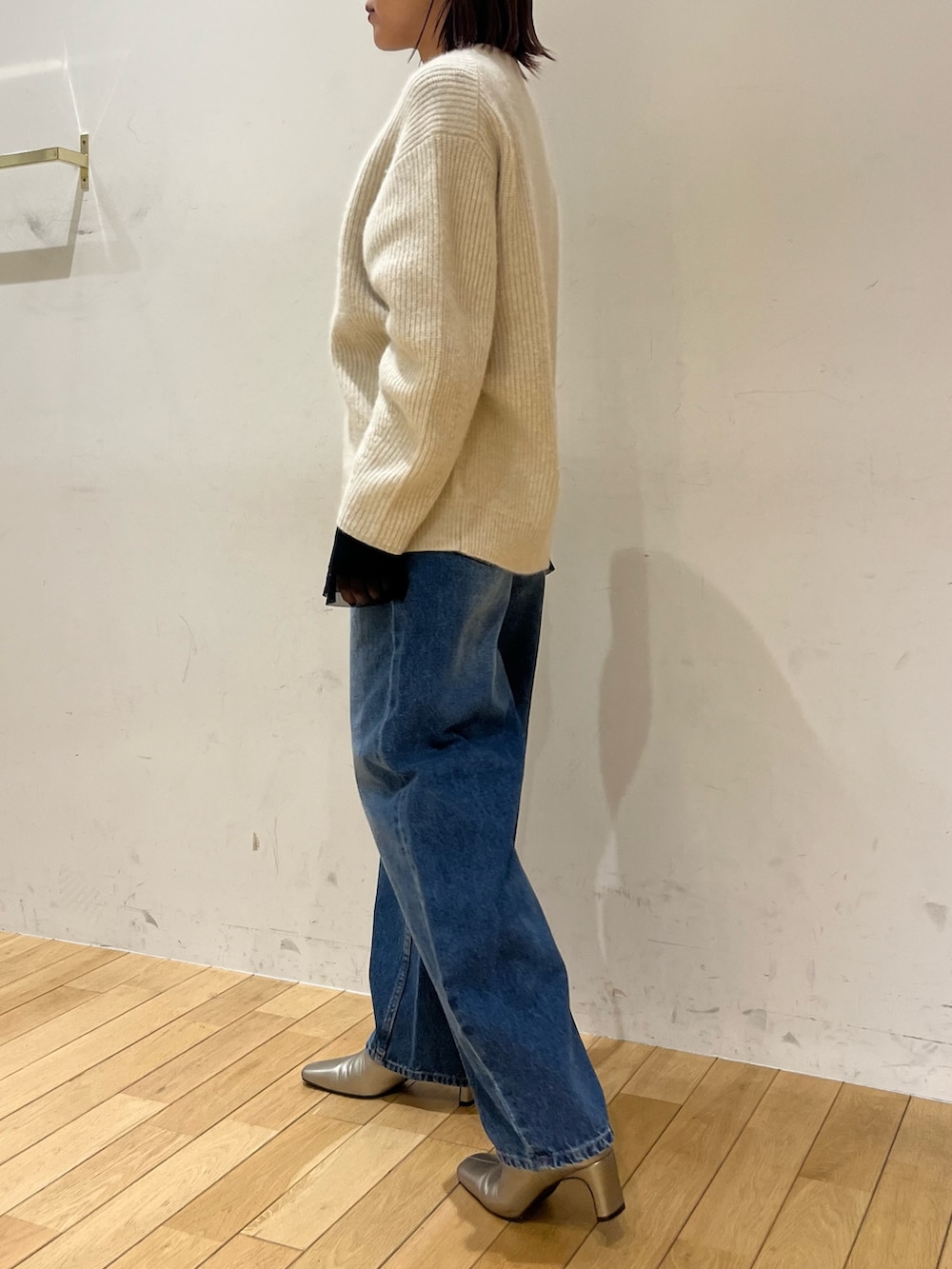 シルバー系のブーツ、ブルー系のデニムパンツ、ブラック系のTシャツ/カットソーを着用したレディースの秋コーディネートの2枚目の写真