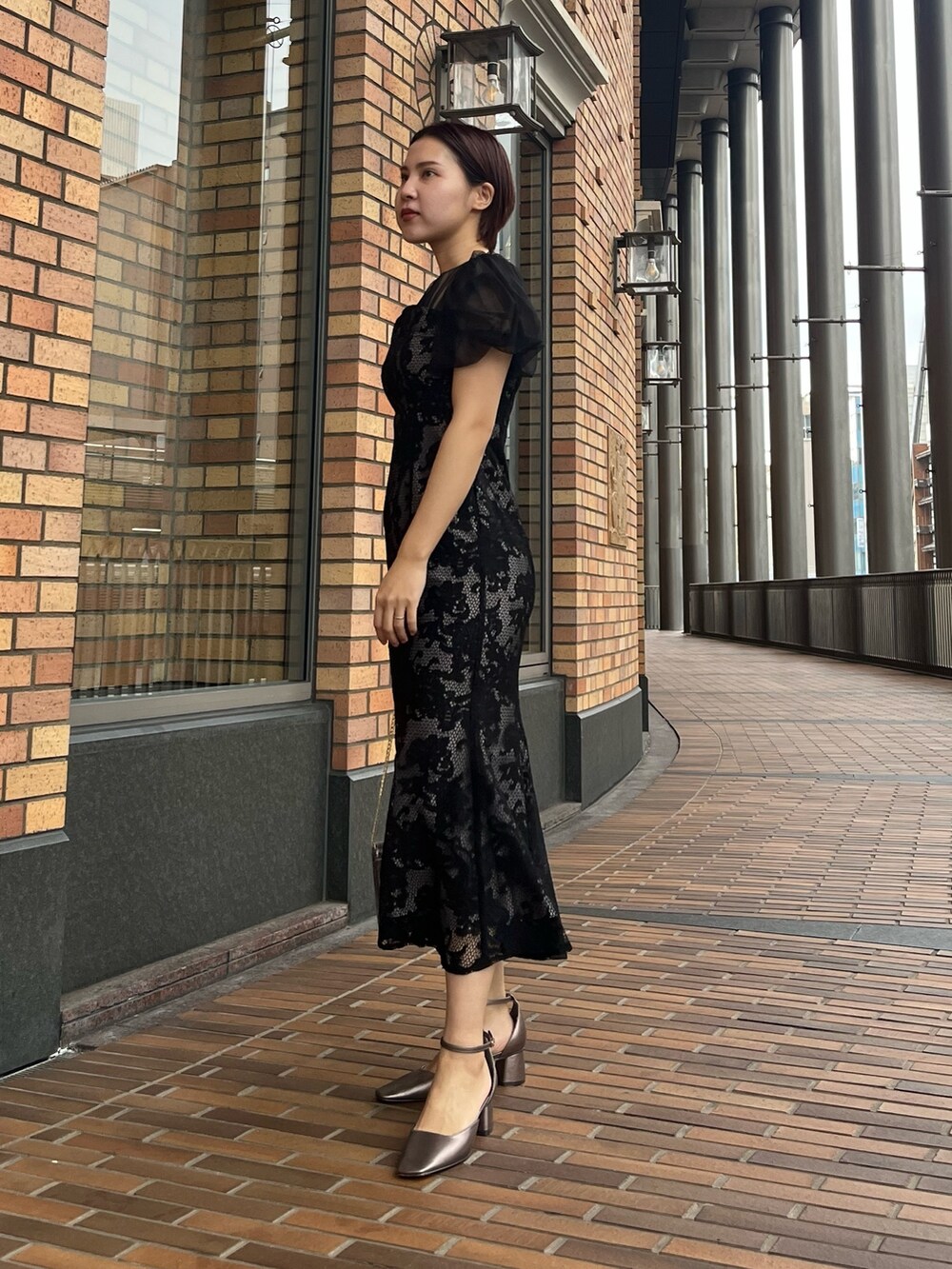 ブラック系のドレス、その他のパンプス、シルバー系のハンドバッグを着用したレディースの冬コーディネートの5枚目の写真