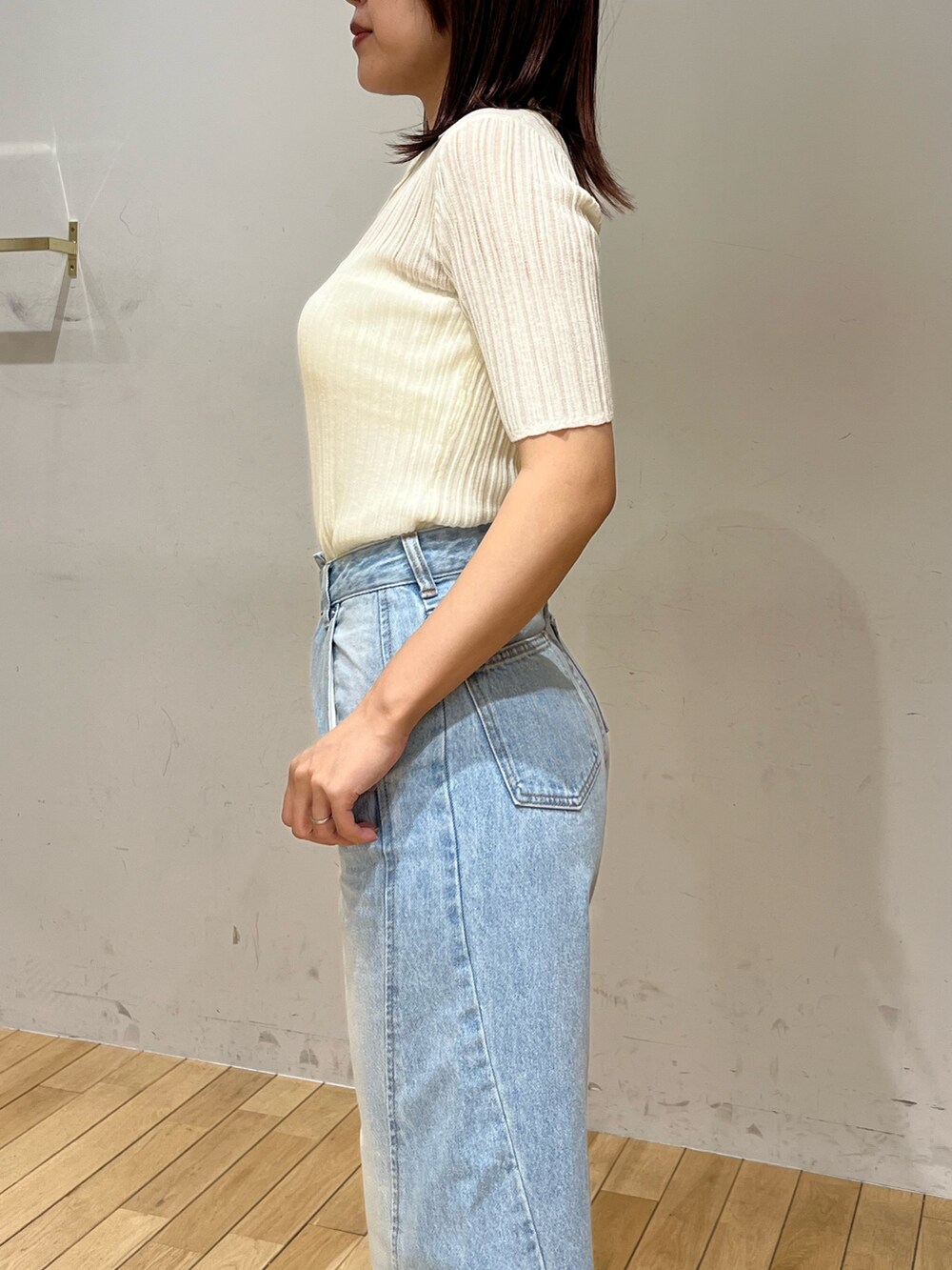 ブルー系のデニムパンツ、ブラック系のサンダル、ホワイト系のTシャツ/カットソーを着用したレディースの春コーディネートの5枚目の写真