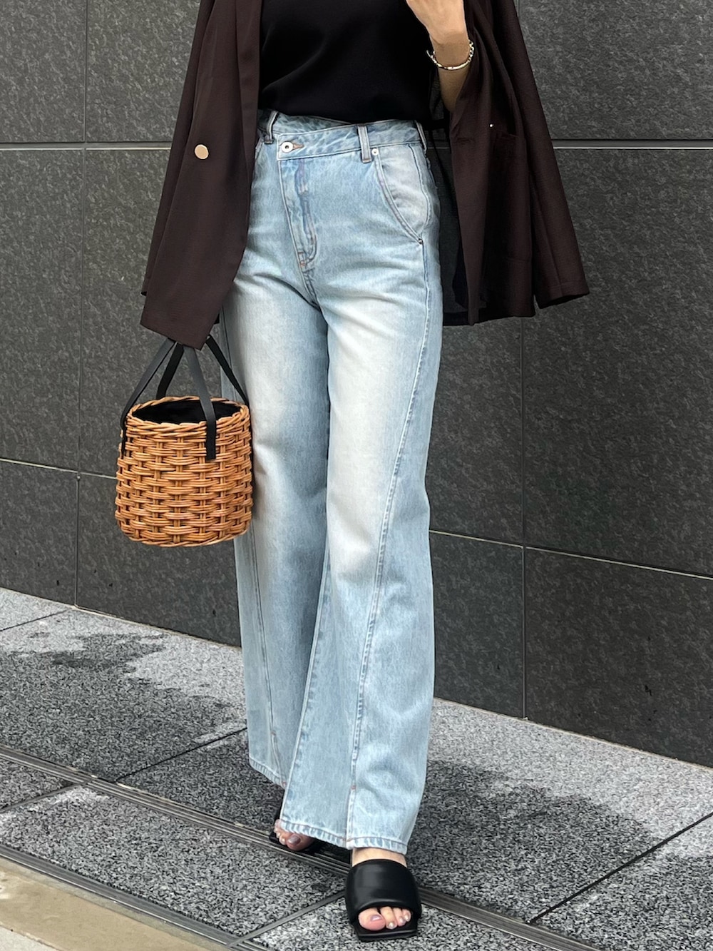 ブラック系のサンダル、ブルー系のデニムパンツ、ブラウン系のテーラードジャケットを着用したレディースの夏コーディネートの7枚目の写真