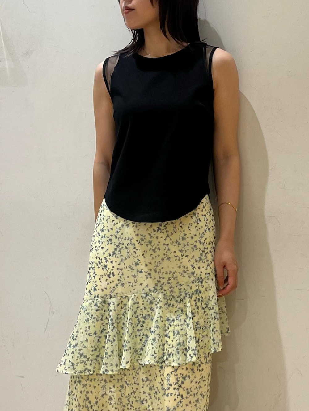 グリーン系のスカート、ブラック系のTシャツ/カットソーを着用したレディースの夏コーディネートの5枚目の写真