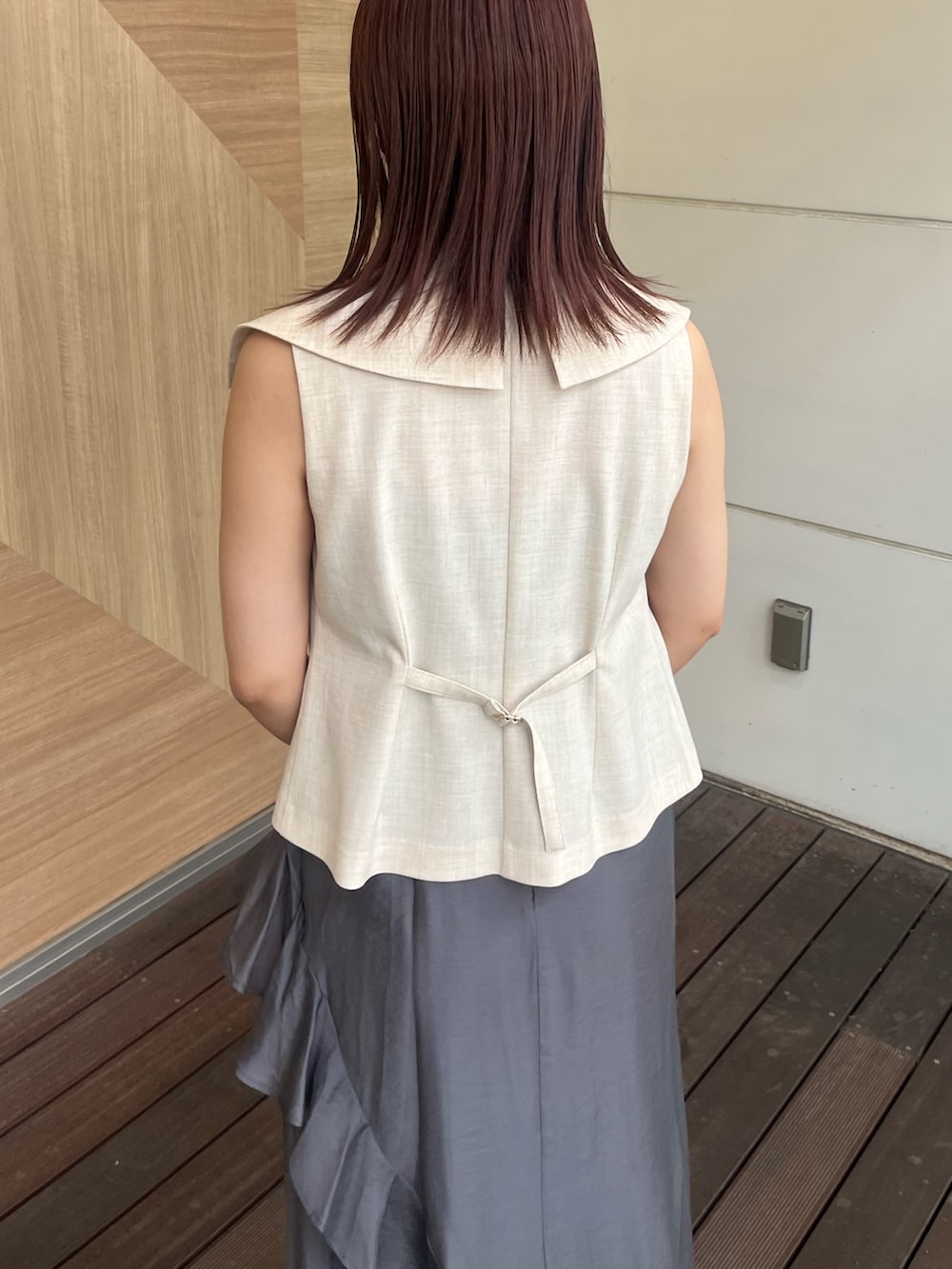ホワイト系のベスト、グレー系のワンピース、ブラウン系のハンドバッグを着用したレディースの夏コーディネートの6枚目の写真