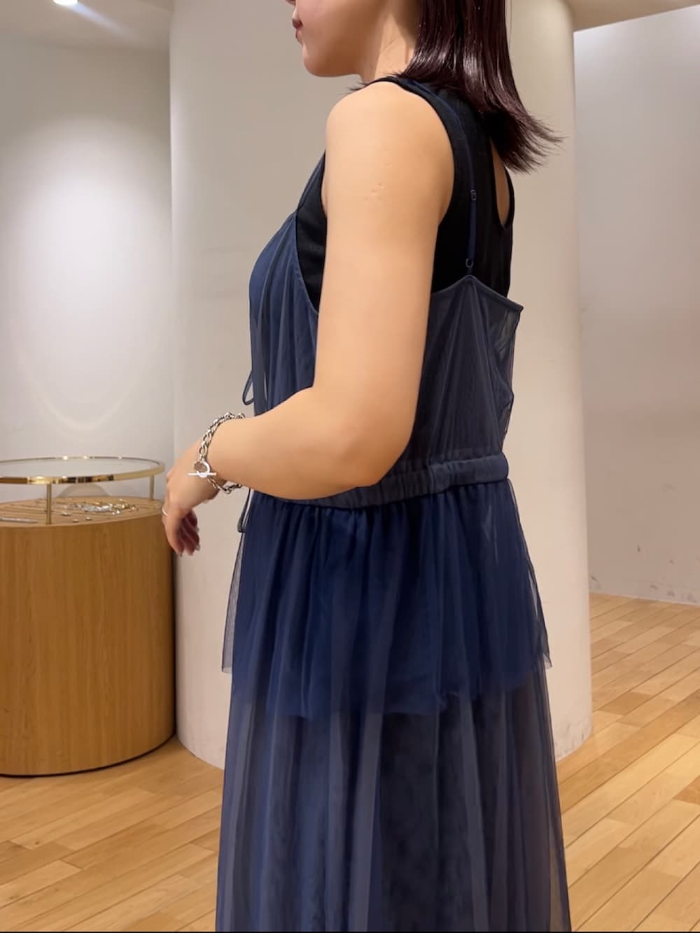 ブラウン系のハンドバッグ、ブラック系のスニーカー、ブルー系のワンピースを着用したレディースの夏コーディネートの6枚目の写真