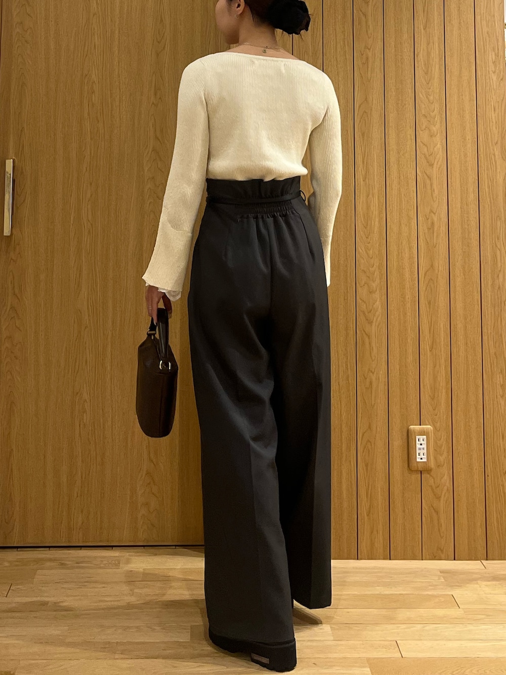 グレー系のその他パンツ、ホワイト系のニット/セーター、ブラウン系のハンドバッグを着用したレディースの冬コーディネートの3枚目の写真