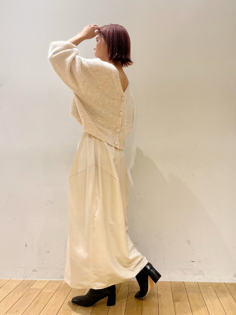 ホワイト系のスカート、ホワイト系のカーディガン/ボレロ、グリーン系のハンドバッグを着用したレディースの秋コーディネートの7枚目の写真