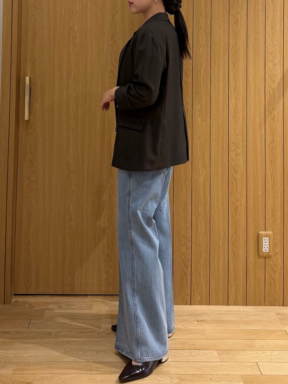 ホワイト系のニット/セーター、ブラウン系のテーラードジャケット、ブルー系のデニムパンツを着用したレディースの春コーディネートの2枚目の写真