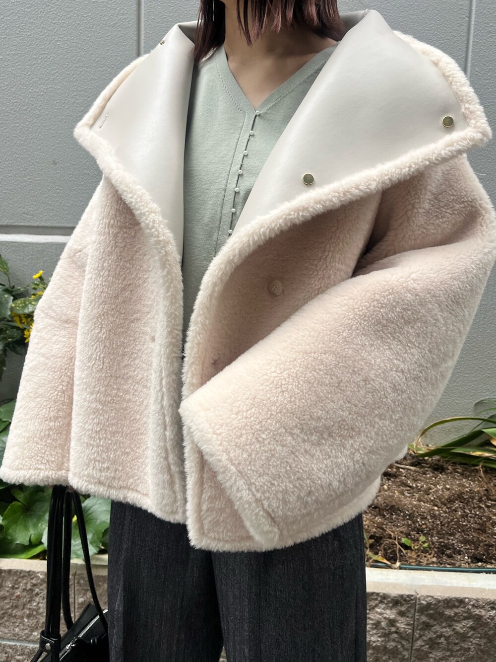ホワイト系のムートンコート、グレー系のその他パンツ、グリーン系のニット/セーターを着用したレディースの冬コーディネートの9枚目の写真