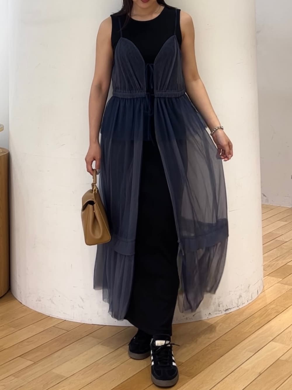 ブラウン系のハンドバッグ、ブラック系のスニーカー、ブルー系のワンピースを着用したレディースの夏コーディネートの4枚目の写真